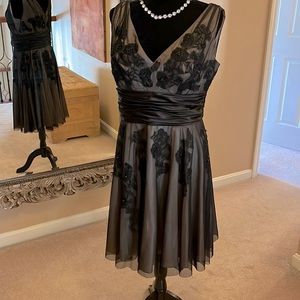 Beautiful cocktail dress in nude with a black sheer overlay with V neck.
